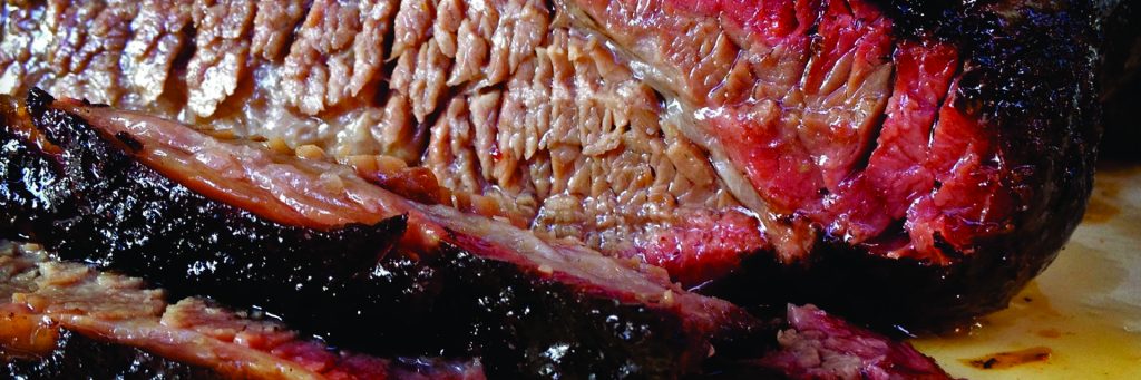 Slow smoked BBQ brisket being sliced